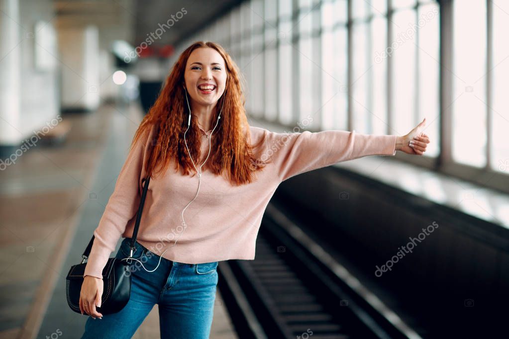 Positive redhead young female stops subway train