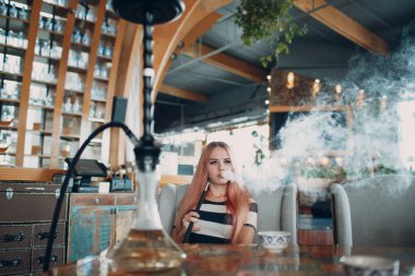 Genç güzel kadın sigara nargile. Shisha nargile Cafe konsept içinde duman.