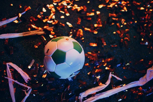 Soccer ball on the field after the game, glitter and tinsel
