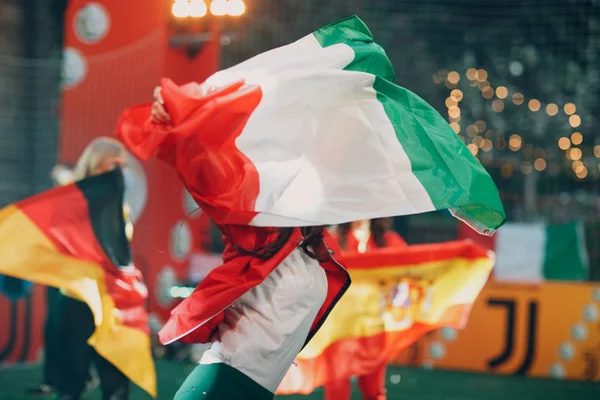 Flags Italy, Germany, Spain during a sports soccer match at a stadium in smoke