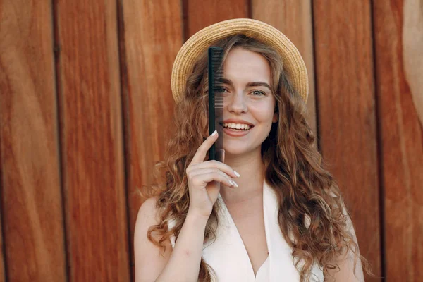 Портрет Молодой Улыбающейся Позитивной Женщины Вьющимися Волосами Соломенной Шляпе Расчёской — стоковое фото