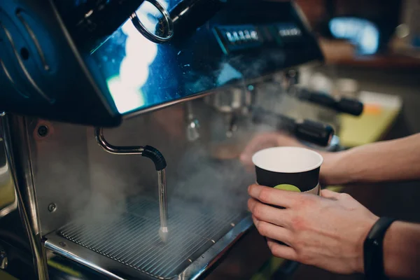 Barista makes coffee in a coffee machine