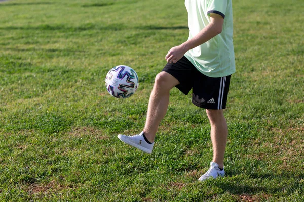 A young boy holding a football ball on a field — Stock Photo, Image