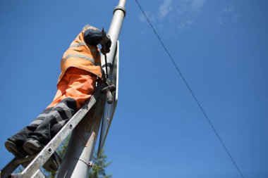 Direğe yol tabelası. Yol işçisi mavi gökyüzü arkaplanına işaret koydu.