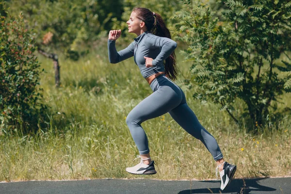 Running girl in city park. Young woman runner outdoor jogging. Side view. — Stock Photo, Image