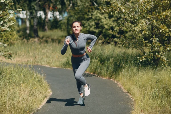Şehir parkında koşan kız. Genç bayan koşucu dışarıda koşuyor.. — Stok fotoğraf