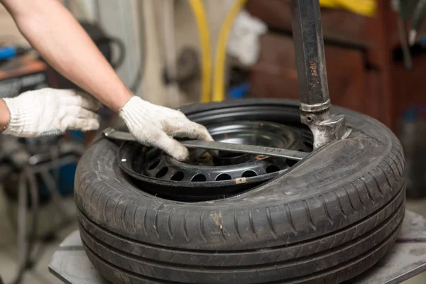 Mecánico cambiando el montaje de neumáticos del coche. Reparación de neumáticos de rueda. —  Fotos de Stock