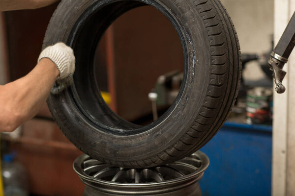 Механик, меняющий шины. Ремонт колесных шин