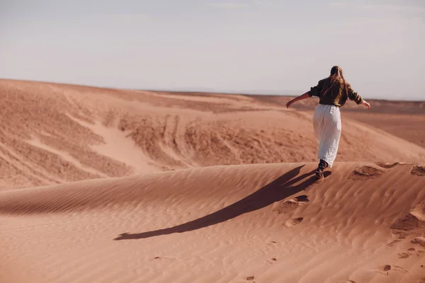 Mujer joven corre sobre dunas de arena en el desierto del Sahara —  Fotos de Stock