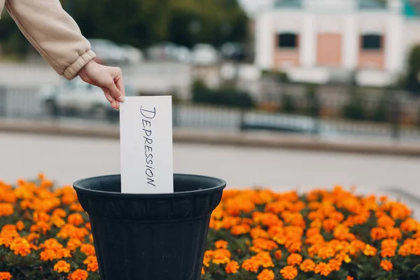 Женщина бросает лист со словом "депрессия" в мусорное ведро. Психология — стоковое фото