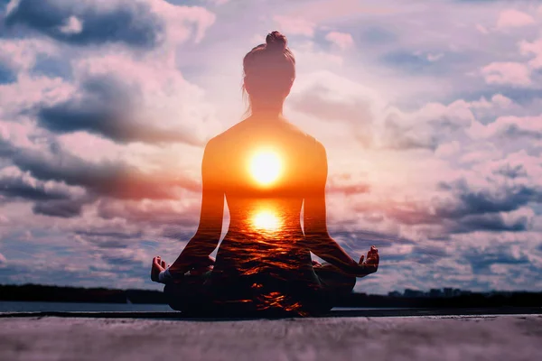 Yoga day concept. Multiple exposure image. Woman practicing lotus asana at sunset. — Stock Photo, Image