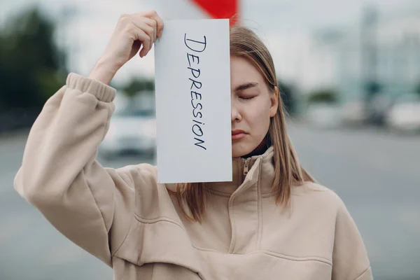 Frau hält weißes Blatt Papier mit der Aufschrift Depression in der Hand. — Stockfoto