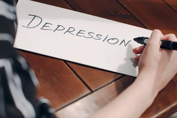 Wanita tangan menulis kata Depresi pada lembar putih — Stok Foto