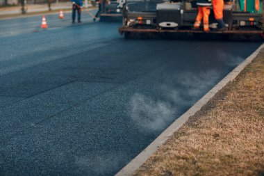 Asfalt kaldırım. Paver makinesi ve yol silindiri. Yeni yol yapımı
