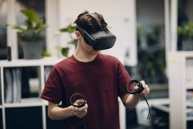 Sanal gerçeklik gözlüklü genç adam, joystick 'li VR gözlükler.