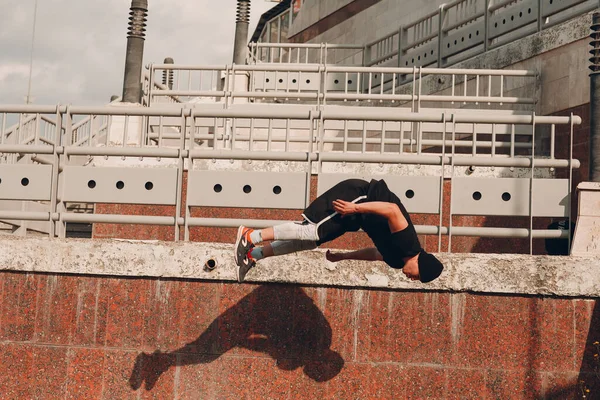 Joven deportista haciendo parkour en la calle de la ciudad. —  Fotos de Stock