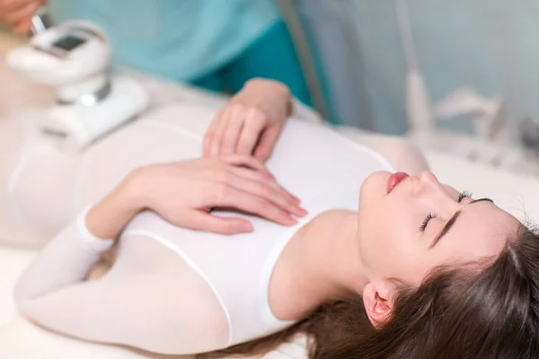 Young beautiful woman and LPG massage stomach procedure in spa clinic. — Stock Photo, Image