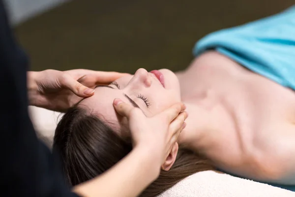 Young beautiful woman receiving head face massage in beauty spa — Stock Photo, Image