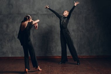 Dans pistinde dans eden siyah elbiseli çift rumba yapıyor..