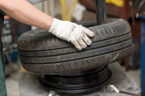 Mecánico cambiando el montaje de neumáticos del coche. Reparación de neumáticos de rueda. —  Fotos de Stock