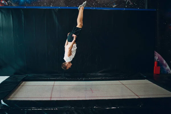 Joven acróbata saltando en trampolín interior . —  Fotos de Stock