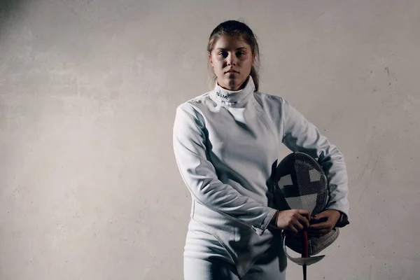 Fencer woman with fencing sword and mask. Looking to camera