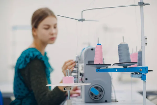 Jonge mooie naaister naait op naaimachine in fabriek — Stockfoto