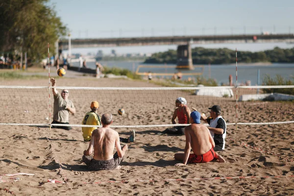 Moskva, Rusland 14 juli 2020: Sit handicappede amputeret volleyball spillere spille på stranden. - Stock-foto