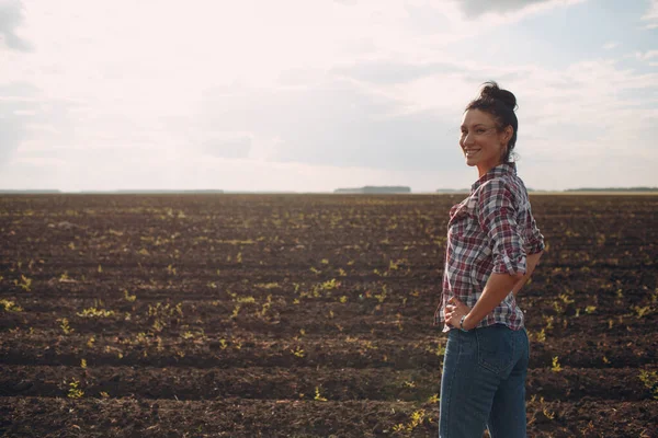 Donna agricoltore in piedi e in cerca di terreno campo agricolo — Foto Stock