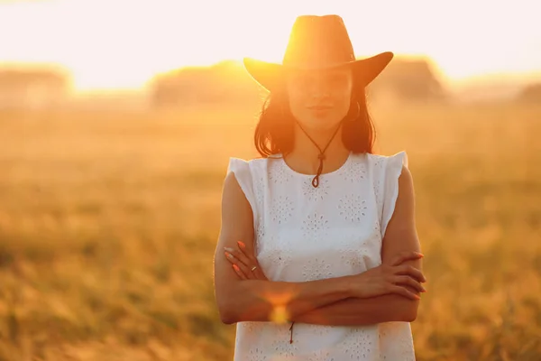 Donna contadino in cappello da cowboy a campo agricolo al tramonto con sunflare — Foto Stock