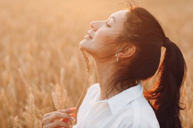Yüzünde buğday kulakları olan güzel bir esmer kadının portresi.