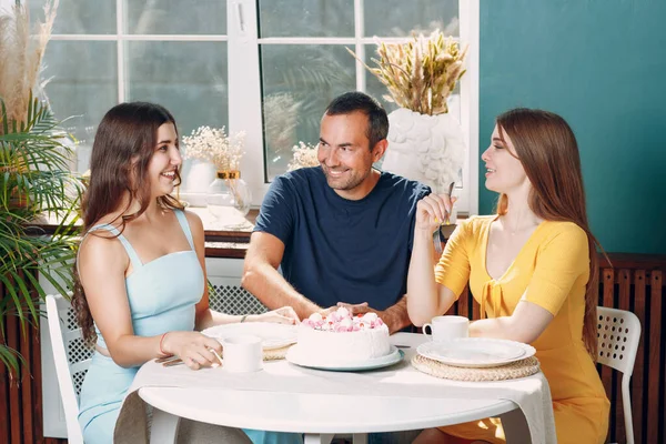 남자와 여자는 아파트 부엌에 앉아 케이크를 식탁에 놓고 생일을 축하 한다 — 스톡 사진