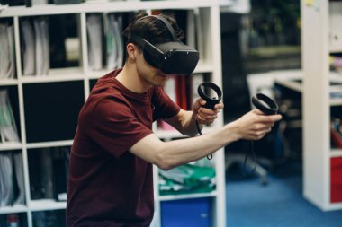 Sanal gerçeklik gözlüklü genç adam, joystick 'li VR gözlükler.
