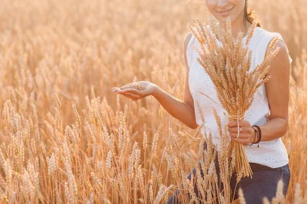 Donna che tiene il covone di spighe di grano a campo agricolo — Foto Stock