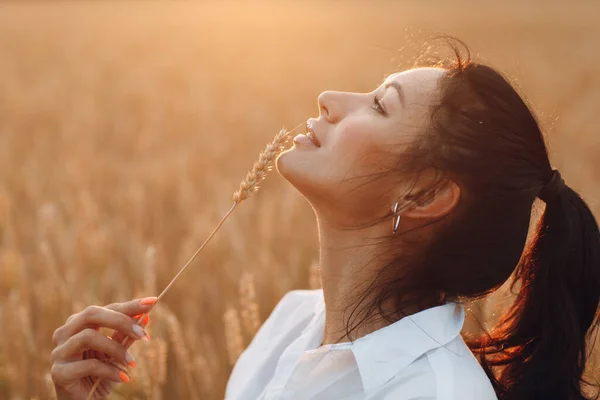 Ritratto di una bella donna bruna con spighe di grano sul viso — Foto Stock