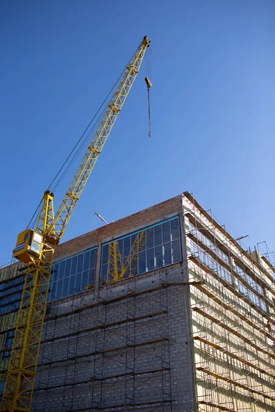 Edificio con grúa de construcción y andamio cielo azul — Foto de Stock