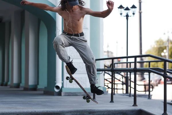 Молодий хлопчик їде трюк на скейтборді в місті — стокове фото