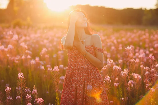 Girl on blooming Sally flower field at sunset. Lilac flowers and woman. — Stock Photo, Image