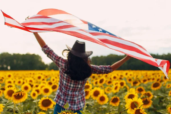O tânără cu steag american pe câmpul de floarea soarelui. 4 iulie Ziua Independenței Conceptul SUA . — Fotografie, imagine de stoc