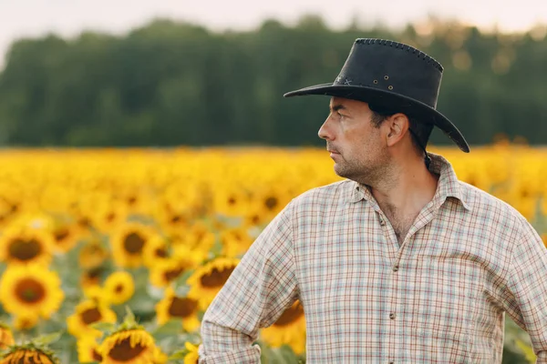 Seorang petani berdiri di ladang bunga matahari. — Stok Foto