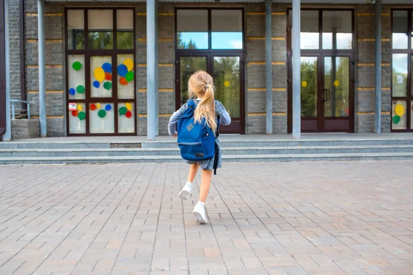 かわいいです女の子とともにバックパックで学校に走ります — ストック写真