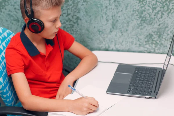 Юный студент в наушниках с ноутбуком обучения и подготовки обратно в школу. Концепция онлайн образования. — стоковое фото