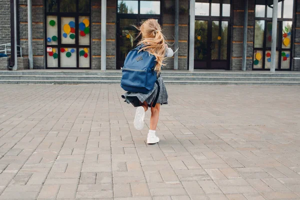 Söt liten flicka med ryggsäck springa tillbaka till skolan — Stockfoto