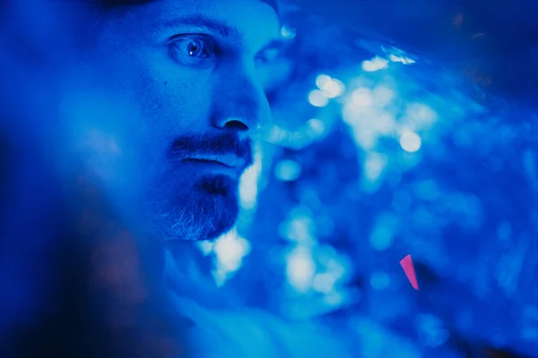 Portrait of adult man with face covered by tin foil in blue light — Stok Foto