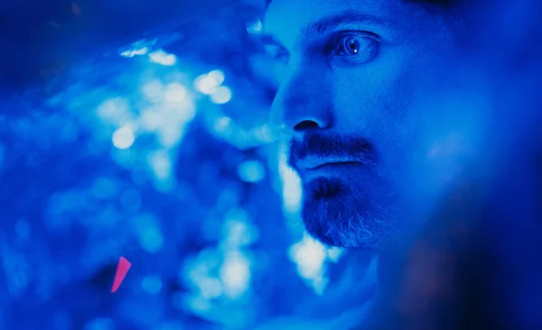 Retrato del hombre adulto con la cabeza cubierta por papel de aluminio en luz azul — Foto de Stock