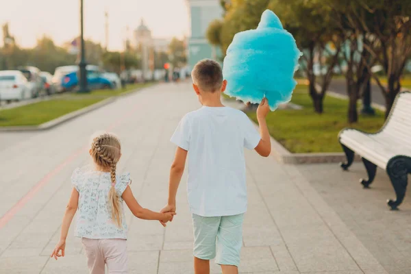 Glückliche Kinder Junge und Mädchen essen blaue Zuckerwatte im Freien — Stockfoto