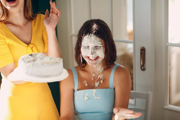 Jovem mulher mergulhar rosto em bolo branco com creme. Conceito de feliz aniversário. — Fotografia de Stock
