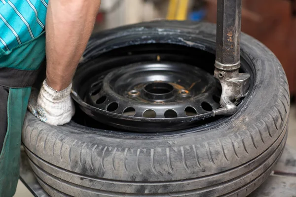 Mecánico cambiando el montaje de neumáticos del coche. Reparación de neumáticos de rueda. —  Fotos de Stock