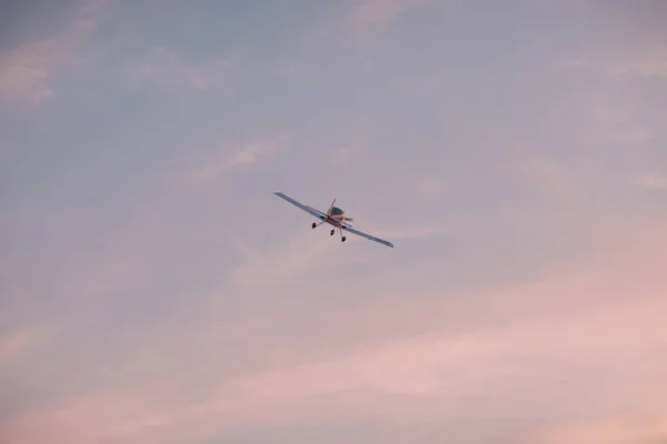 Mały samolot jednosilnikowy lecący przed zachodem słońca — Zdjęcie stockowe