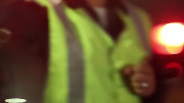 Blaulicht eines Streifenwagens der Polizei und Verkehrspolizist in der Nacht — Stockvideo